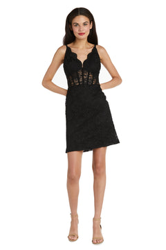 A woman models the Morgan 12976 short lace party dress, featuring a sleeveless corset bodice and v-neckline in black, paired with nude heels, standing against a white background.