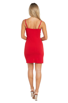 A woman stands with her back to the camera, wearing the Morgan 12977 short semi-formal dress in a fitted red tulip skirt style and clear high-heeled shoes against a white background.