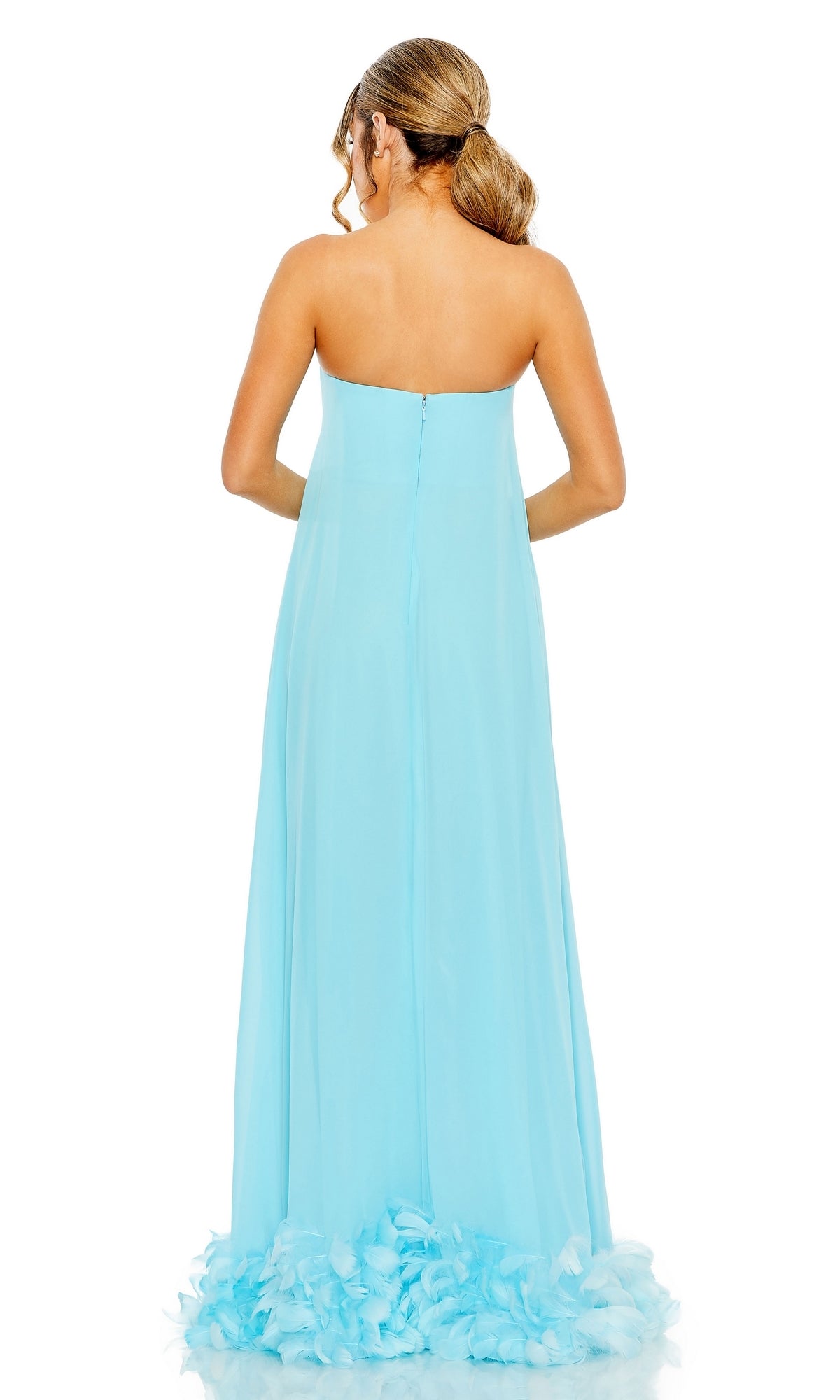 A woman models the Mac Duggal 13001 Strapless Trapeze Formal Gown in light blue, featuring a flowy skirt and ruffled hem, shown from the back.