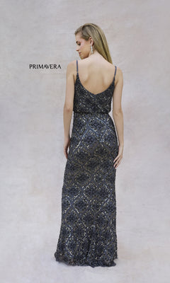 A woman faces away against a light background, wearing the Primavera 13139 long formal dress—sleeveless, floor-length, with black and silver beading and a blouson bodice. The label "Primavera" appears beside her.