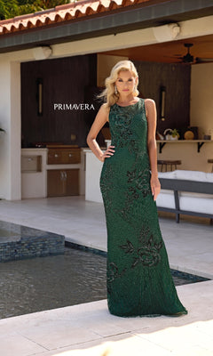 A woman wearing the Primavera 13140 sleeveless long formal dress with an illusion-sweetheart neckline stands by a pool on an outdoor patio. The word "PRIMAVERA" is displayed beside her.