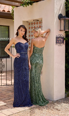 Two women wear Primavera 13141 long formal dresses—one in navy blue facing forward, the other in green facing away—standing outdoors by a white stucco wall.