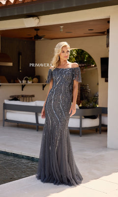 A woman in the Primavera 13155 long formal dress with short sleeves and sequin mermaid design.