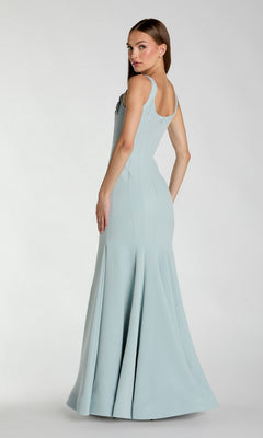 A woman models the Mac Duggal 13224 Long Formal Dress, a light blue, sleeveless, floor-length mermaid gown, posing with her back slightly turned and head looking over her shoulder against a plain white background.