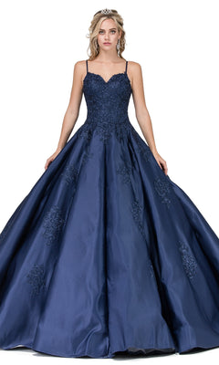 A woman gracefully poses in the Quinceanera Dress 1325 by Dancing Queen—a navy blue a-line ball gown with lace applique, thin straps, and a tiara—spreading out the skirt.