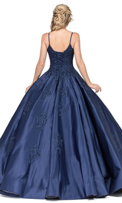A woman with braided blonde hair models the Quinceanera Dress 1325 by Dancing Queen, a navy blue sleeveless A-line ball gown with lace applique, shown from the back against a white background.