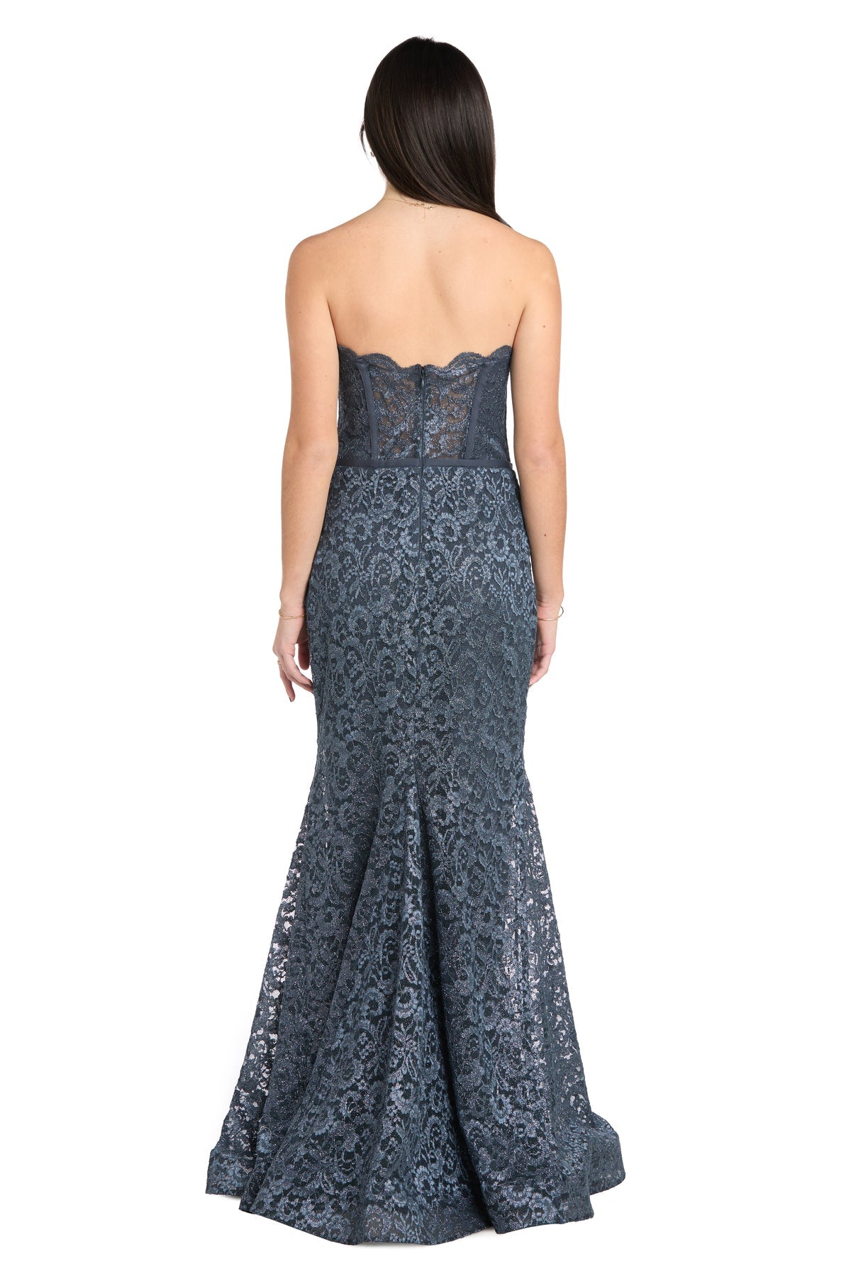 A woman faces away, wearing the Strapless Long Lace Prom Dress: Morgan 13269 in dark blue. This elegant gown features a fitted bodice and a flared, floor-length mermaid skirt crafted from lace.