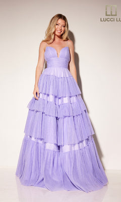 A woman stands against a plain backdrop wearing the Tiered Ruffled Glitter Prom Dress: Lucci Lu 1357, featuring lavender color, a deep V neckline, and floor-length tiered ruffles.