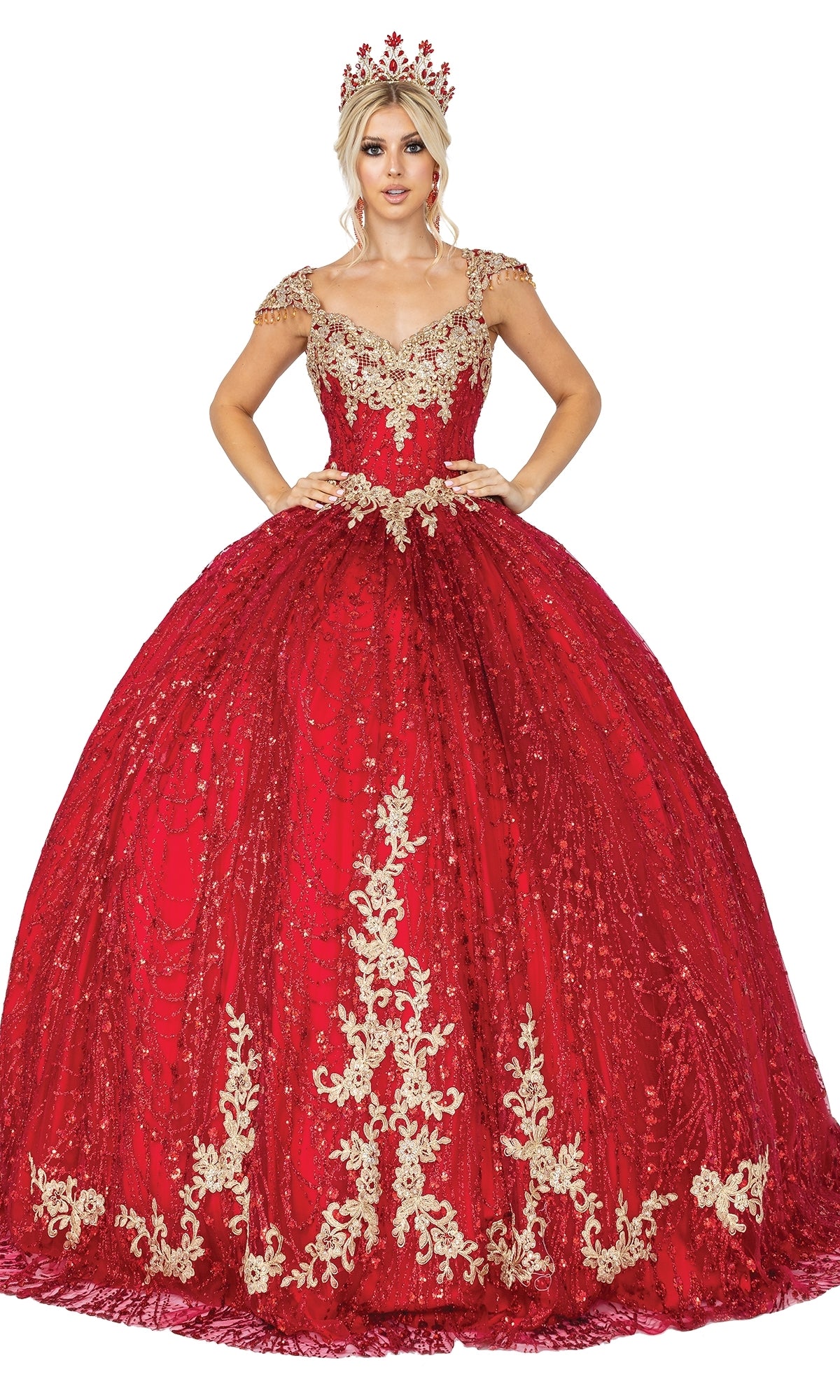 A woman in the Quinceanera Dress 1397 by Dancing Queen, featuring a red a-line ball gown with gold embroidery, sweetheart neckline, and matching crown, poses with her hands on her waist against a white background.