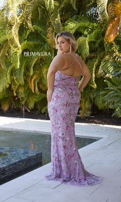 A woman stands by a pool framed by palm trees, wearing the Primavera 14071 Plus-Size Beaded Prom Gown—a floor-length formal dress with an open back and crisscross straps.