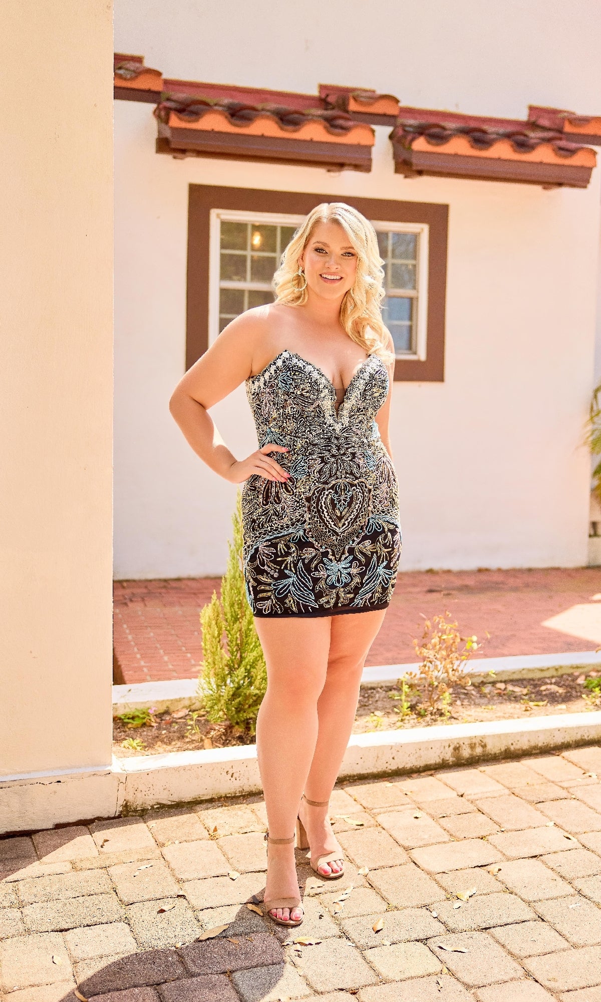 Woman in a patterned dress standing outside a house