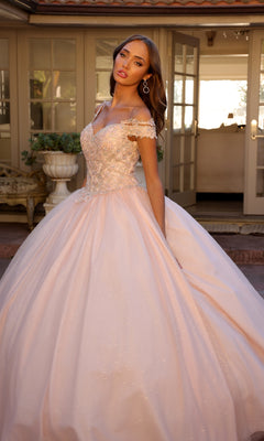 Woman wearing the Juliet 1430 Cold-Shoulder Glitter Quinceanera Dress poses outdoors in front of glass doors and potted plants.
