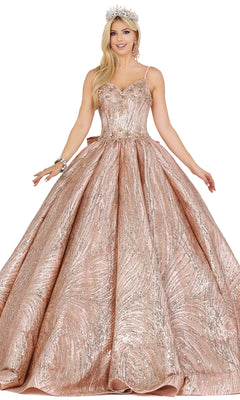 A woman in the Quinceanera Dress 1447 by Dancing Queen, featuring sparkling lace embroidery in rose gold with thin straps and a full skirt, accessorized with a silver crown and bracelet, stands against a white background.