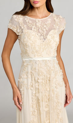 Woman wearing a cream Mac Duggal 14521 cap-sleeve long formal dress with floral embroidery, sheer upper bodice, and satin waistband—a perfect choice for special occasions.