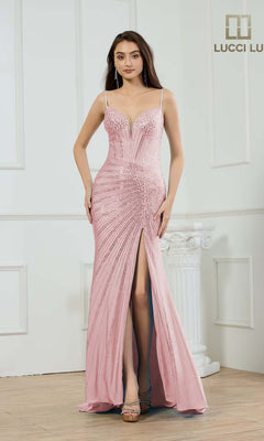 A woman stands indoors wearing the Lucci Lu 1456, a pink long prom dress with thin straps, beaded embellishments, a deep neckline, and a high front slit.