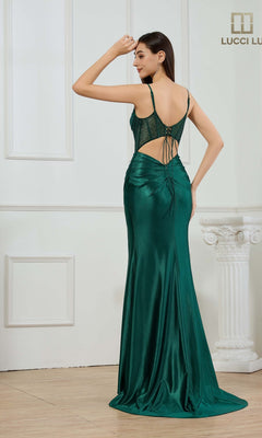 A woman in the Lucci Lu 1462 Long Prom Dress, featuring green satin, a lace-up open back, and an elegant corset bodice, stands indoors facing away and looks over her shoulder.