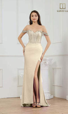 A woman poses indoors against white paneled walls and a column wearing the gold Lucci Lu 1466 long prom dress, featuring an off-the-shoulder neckline, fitted corset bodice, glitter sheath skirt, and silver embellishments.