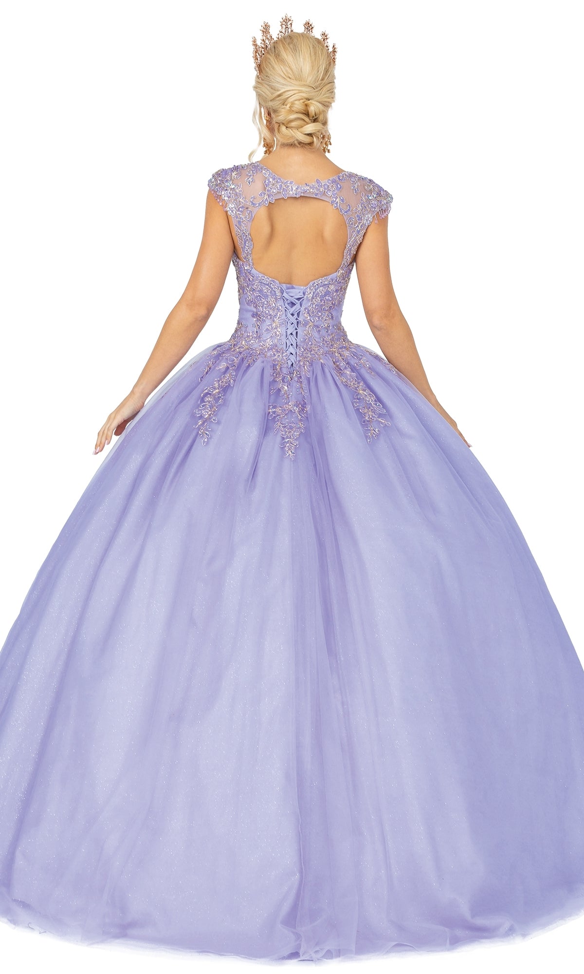 A woman in the Quinceanera Dress 1470 by Dancing Queen stands facing away, showing off its lavender hue, lace details, open back, and full skirt, crowned for a regal look.