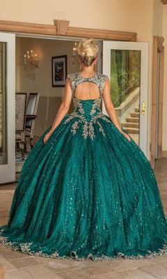 A woman wearing the Quinceanera Dress 1478 by Dancing Queen, featuring a green ball gown with a lace embroidered corset bodice and silver embellishments, stands facing away in front of open glass doors in a bright room.