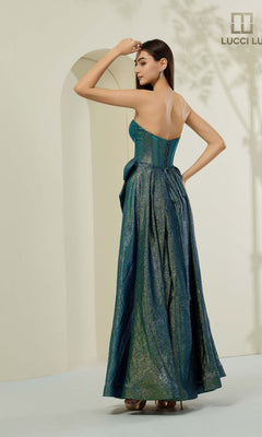 A woman stands indoors, wearing the Lucci Lu 1481 long prom dress in shimmering teal with a strapless corset bodice, looking over her shoulder as she touches her head.