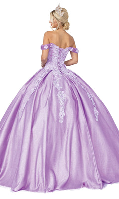 A woman wearing a tiara and the Quinceanera Dress 1501 by Dancing Queen—a floor-length, lavender a-line ball gown with lace details and off-the-shoulder sleeves—stands facing away.
