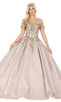A woman stands with arms slightly extended, wearing the Quinceanera Dress 1504 by Dancing Queen—an off-the-shoulder, light pink a-line ball gown featuring lace embroidery, gold floral details, complemented by a tiara and earrings.