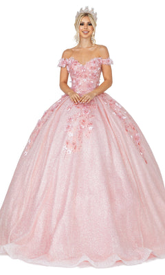 A woman smiles in the elegant Quinceanera Dress 1527 by Dancing Queen—a sparkling pink off-the-shoulder ball gown with floral embellishments and a jeweled crown.