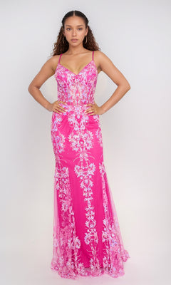 A woman faces forward in the Nina Canacci 1562 long formal dress, a pink fitted mermaid gown with white floral embroidery and thin straps, standing against a plain light background.