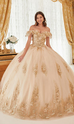A young woman poses gracefully indoors by a piano and gold curtains in the Ladivine 15701 Glitter Quince Dress, an off-the-shoulder ball gown featuring gold embellishments, a full tulle skirt, and a statement back bow.