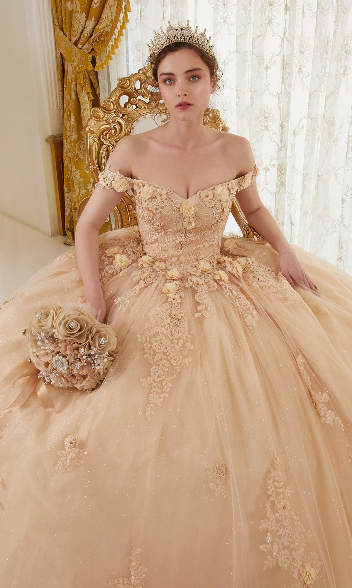 A woman in the Ladivine 15702 Quinceañera Dress with 3-D Flowers (peach, off-the-shoulder) sits on a gold chair holding a matching bouquet, with lace curtains and gold drapes in the background.