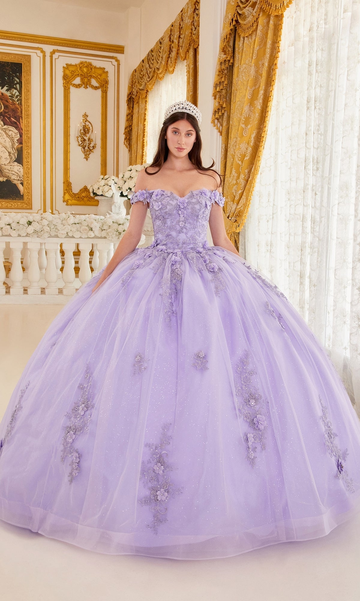 A young woman in the Ladivine 15702 Quinceañera Dress with 3-D flowers and a tiara stands in an ornate room with gold curtains and framed art.