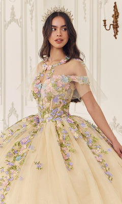 A woman wears the Quinceanera Dress 15724 by Ladivine—a light yellow ball gown with floral embroidery and a sheer overlay—indoors, styled with a decorative crown.