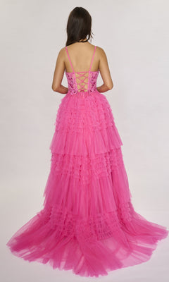 A woman with long brown hair faces away, wearing the Nina Canacci 1582—a bright pink long formal dress with a lace-up back and A-line ruffle tiered tulle skirt, flowing gracefully against a plain light background.