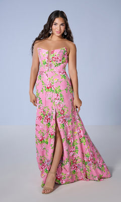A woman models the Long Prom Dress: Tiffany 16143, a strapless floral gown with pink accents and a front slit, standing before a plain light blue background.