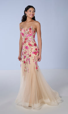 A woman wears the Long Prom Dress: Tiffany 16148, a sleeveless, form-fitting mermaid gown with a sheer tulle skirt and vibrant embroidered lace applique, standing against a plain light background.