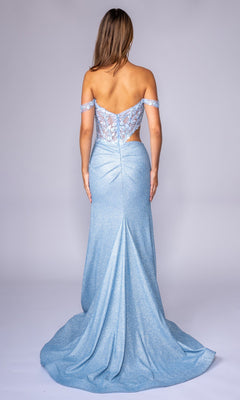 A woman wears the Nina Canacci 1618, a long formal light blue off-the-shoulder prom dress with lace, sheer back detailing, and delicate floral embroidery, posing elegantly against a plain background.
