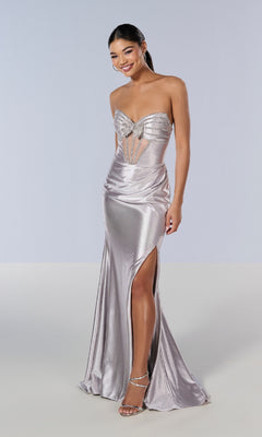 A woman wearing the Long Prom Dress: Tiffany 16199—a strapless, metallic silver gown with a glitter finish, thigh-high slit, and embellished bodice—smiles against a plain background in high-heeled sandals.