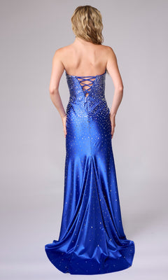 A woman in the Long Formal Dress: Nina Canacci 1619, a strapless royal blue gown with a sweetheart neckline, lace-up back, and rhinestone details, stands facing away from the camera.