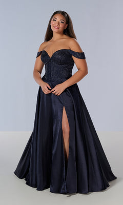 A woman poses in the Tiffany 16204 long plus-size prom dress, featuring an elegant navy off-the-shoulder design with a fitted bodice, sweetheart neckline, and high slit, standing out against a simple light background.