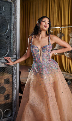 A woman in the Long Prom Dress: Tiffany 16206, featuring sparkly beaded tulle and crystal embellishments, poses indoors beside a large speaker and draped gold curtains.