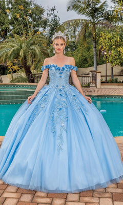 A woman stands by a pool surrounded by palm trees, wearing the Quinceanera Dress 1620 By Dancing Queen—a light blue, off-the-shoulder gown with floral details and a sweetheart neckline.