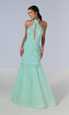 A woman stands against a plain background wearing the Tiffany 16210 long prom dress—a sleeveless, light aqua blue sequin mermaid gown with a keyhole neckline and open back.