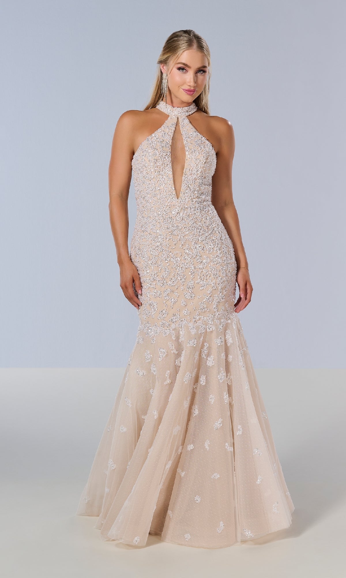 A woman stands against a plain background wearing the Tiffany 16210 long prom dress—a sleeveless, light mermaid gown with sequin embellishments, a front keyhole cutout, and an open back.