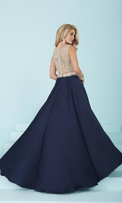 A woman stands on light blue steps with her back to the camera, wearing a navy Two-Piece Long A-Line Prom Dress featuring a beaded sleeveless top and a floor-length skirt.