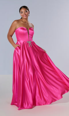 Model wearing the Tiffany 16219 long plus-size prom dress in bright pink satin, strapless with a deep neckline and jeweled bow at the waist, standing against a plain background.