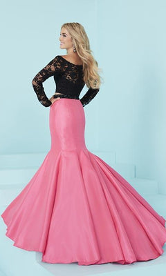 A woman stands on pale blue stairs wearing the Two-Piece Mermaid Prom Dress with Lace Sleeves, featuring loose waves in her hair and a floor-length pink mermaid-style skirt.