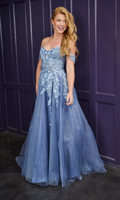 A woman stands smiling in front of a purple paneled wall, wearing the Tiffany 16243 long prom dress in blue, featuring off-the-shoulder sleeves, floral embroidery, and glitter tulle details.