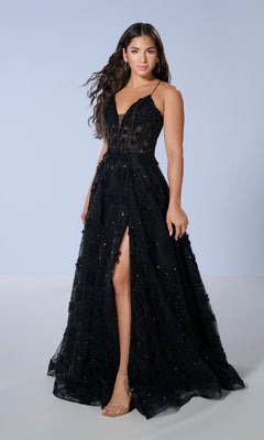 A woman stands against a plain light background wearing the Tiffany 16247 Long Prom Dress—a sleeveless, black, floor-length gown featuring a sheer bodice, subtle embellishments, and a front slit.