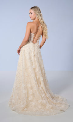 A woman poses against a plain, light background wearing the Long Prom Dress: Tiffany 16247—a floor-length champagne gown featuring a sheer bodice, sequin accents, and a delicate floral pattern.
