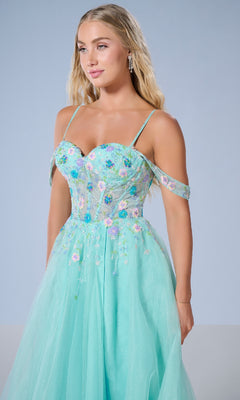 A woman stands against a plain light blue background wearing the Long Prom Dress: Tiffany 16251, a light blue off-the-shoulder A-line gown with floral beaded appliqué and thin straps.